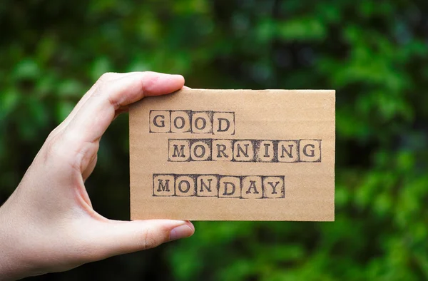 Woman hand holding card with words Good Morning Monday