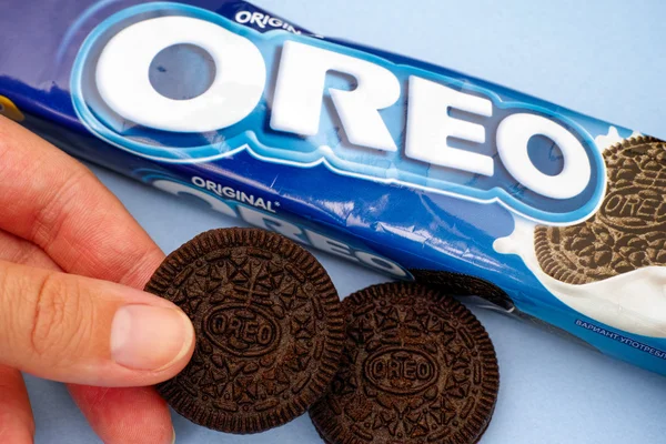 Oreo pack e biscoito na mão da mulher — Fotografia de Stock