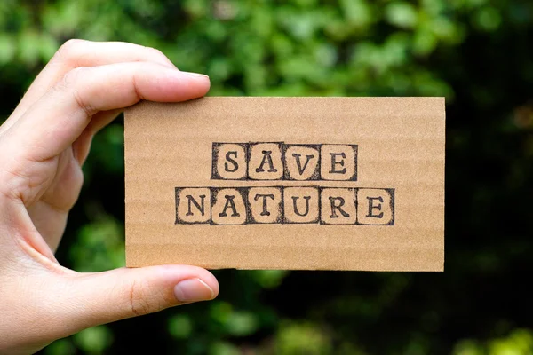 Woman hand holding cardboard card with words Save Nature — Stock Photo, Image
