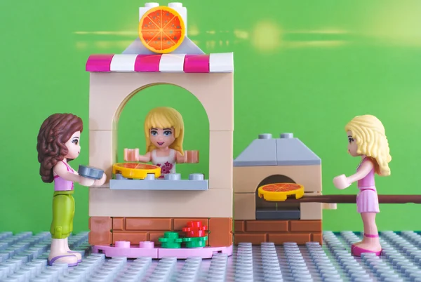 Lego Друзья девушки с монетами, покупающие пиццу в пиццерии — стоковое фото