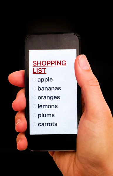 Λίστα για ψώνια στο έξυπνο τηλέφωνο οθόνη στο χέρι γυναίκα — Φωτογραφία Αρχείου