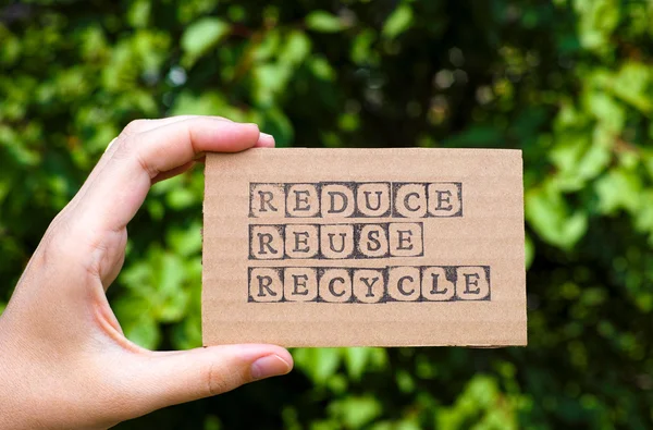 Kvinnan handen håller kartong kort med ord minska återanvända återvinna — Stockfoto