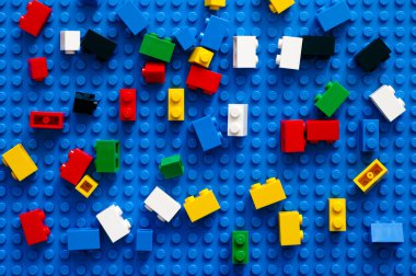 Multicolor Lego Blocks on blue baseplate. clipart