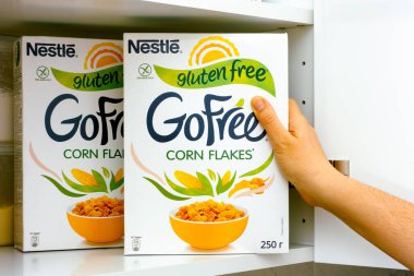 Tambov, Rusya Federasyonu - 25 Ocak 2021 Nestle Gluten 'siz mısır gevreği kutusunu dolaptan çıkaran kadın eli