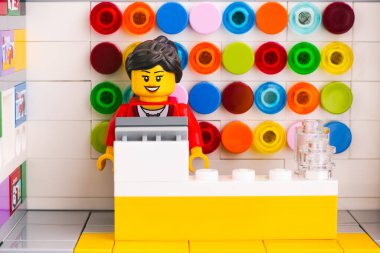 Tambov, Rusya Federasyonu - Haziran 06, 2020 Lego satıcısı minifiki bir LEGO mağazasında kasada çalışıyor. Stüdyo çekimi.