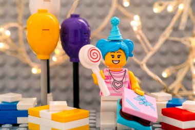 Tambov, Rusya Federasyonu - 17 Ocak 2021 Lego doğum günü kızı lolipopu, hediyeleri ve balonları ile birlikte gri tabağa karşı