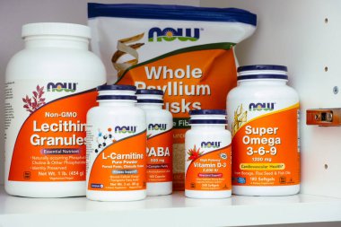 Tambov, Russian Federation - March 19, 2021 Bottles and packages with nutritional supplements by NOW on shelf in the kitchen cupboard