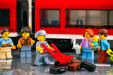 Tambov, Rusya Federasyonu - 3 Mart 2021 Lego kapıcısı, kırmızı trenin önüne bavullarını serdi.