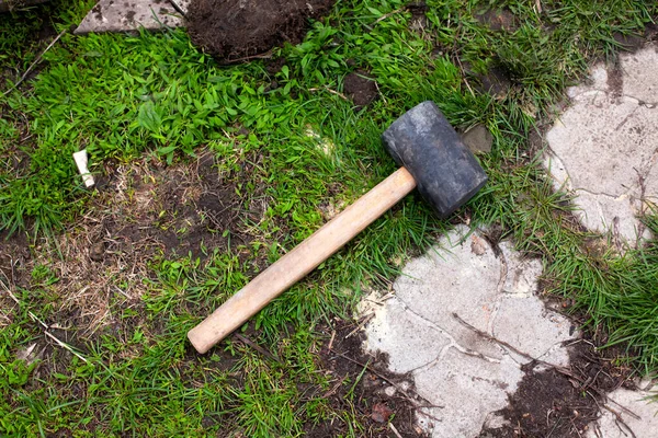 A Rubber mallet laying on grass outdoors