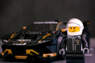 Tambov, Rusya Federasyonu - 25 Haziran 2020 LEGO Speed Champions 'ın Lamborghini Huracan Super Trofeo EVO arabasına karşı minyatür Lego sürücüsü. Stüdyo çekimi.