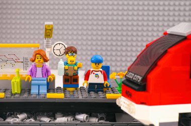Tambov, Rusya Federasyonu - 03 Mart 2021 Lego ailesi tren istasyonunda bekliyor. Lego gri taban tabanı arka planı. 