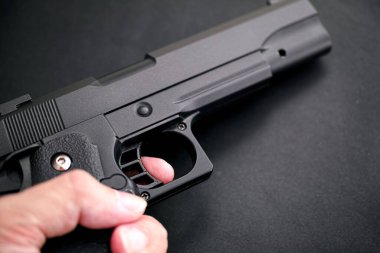 Siyah arka planda gerçekçi siyah havalı silah (Glock 23).