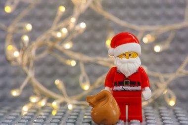 Tambov, Rusya Federasyonu - 17 Ocak 2021 Lego Noel Baba minyatür figürü Noel ışığı arka planında hediye dolu çanta