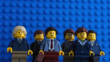 Tambov, Rusya Federasyonu - 18 Temmuz 2021 Lego iş adamları Mavi bir Lego ana levhasına karşı duran minyatür figürler