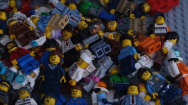 Tambov, Rusya Federasyonu - 16 Temmuz 2021 Lego gri tabaka üzerinde yığınla Lego minyatür figürü yatıyor