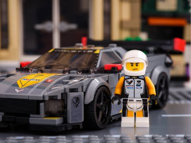 Tambov, Rusya Federasyonu - 02 Temmuz 2021 Lego Chevrolet Corvette C8.R yarış arabası sürücüsü minifiki LEGO Speed Champions tarafından arabasının yanında duruyor.