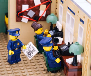 Tambov, Rusya Federasyonu - 2 Ağustos 2021 Polis karakolunda çalışan üç Lego polisi. Bir polis memuru gazete tutuyor. Bir diğeri çağrıya cevap veriyor ve sonuncusu daktiloyla daktilo yazıyor.