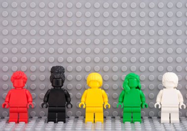 Tambov, Rusya Federasyonu - 12 Ağustos 2021 Beş Lego tek renkli minyatür figürü Gri bir Lego ana plakasına karşı durmaktadır.