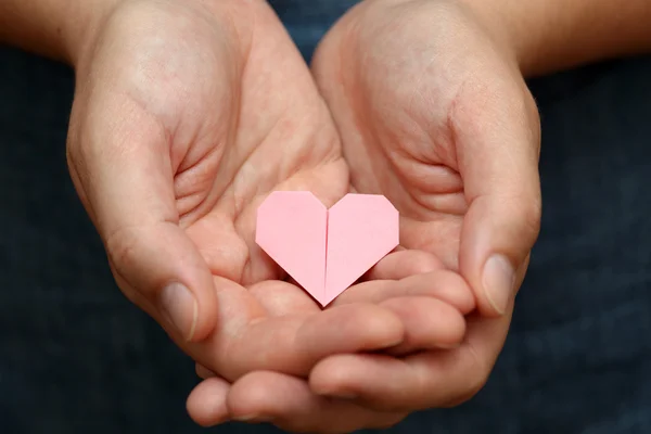 Origami heart in human hands. — Stock Photo, Image