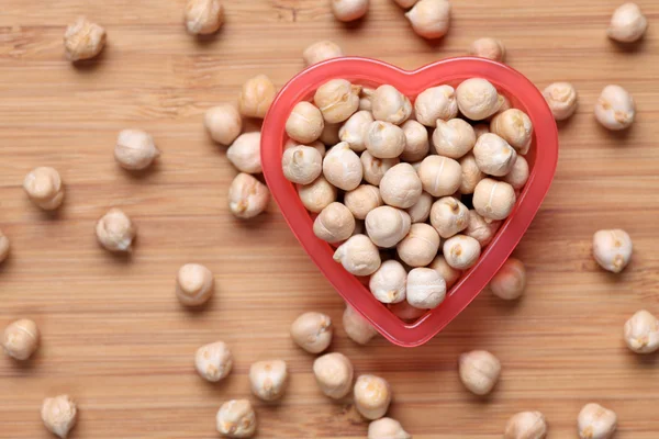 Chickpeas in a heart bowl — Stock Photo, Image