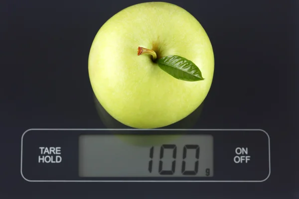 Zelené jablko na váhu — Stock fotografie