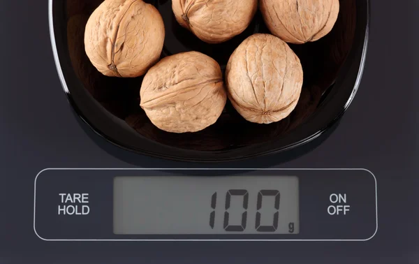 Walnuts on kitchen scale — Stock Photo, Image