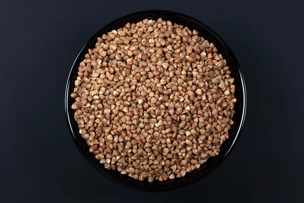 Buckwheat in black bowl — Stock Photo, Image