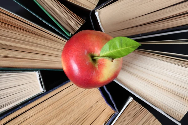 Old hardback books and apple — Stock Photo, Image