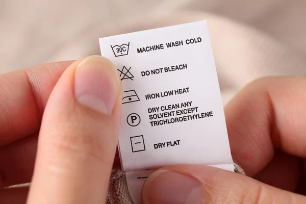 Etiqueta de roupa com instruções de limpeza Imagem De Stock