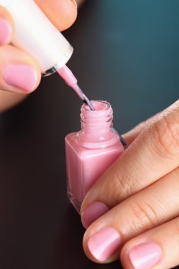 Pembe oje kadın elinde şişe