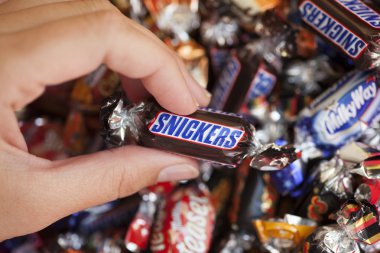 Snickers candy in woman's hand clipart