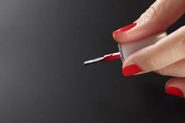 Cepillo esmalte de uñas rojo en mano mujer —  Fotos de Stock