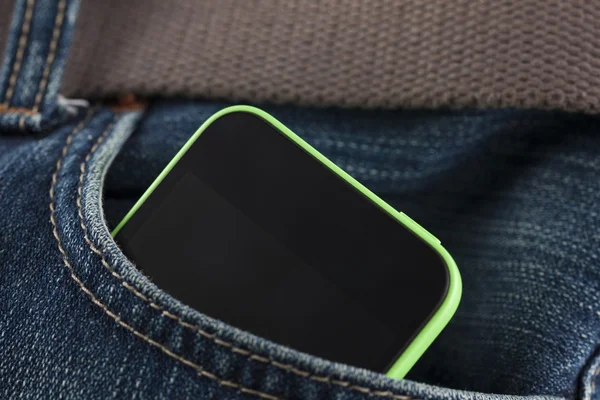 Teléfono móvil en un bolsillo de jeans — Foto de Stock