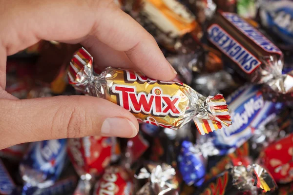 Twix Bonbons in der Hand der Frau — Stockfoto