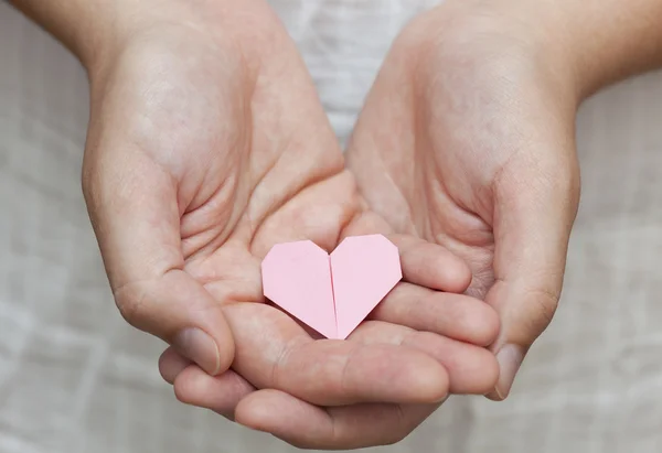 Origami heart in human hands — Stock Photo, Image