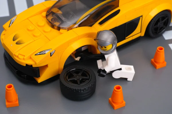 Lego driver is fixing wheel of McLaren P1 by Lego Speed Champion — Stock Photo, Image