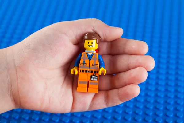 Lego жорсткий капелюх Emmet minifigure в рука дитини — стокове фото
