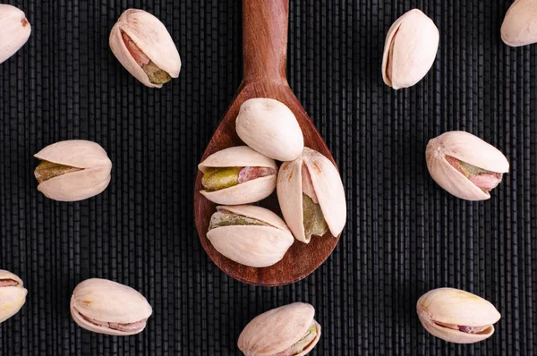 Pistachio nuts in wooden spoon — Stock Photo, Image