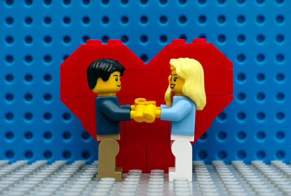 Lego çift ayakta kalp önünde