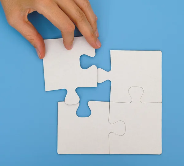 Woman hand putting final piece of puzzle — Stock Photo, Image