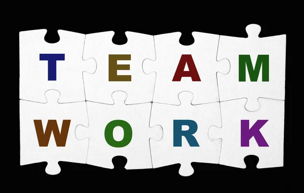 Teamwork Puzzle auf schwarzem Hintergrund — Stockfoto