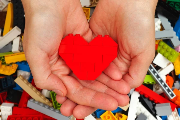 Lego corazón rojo en las manos de la mujer —  Fotos de Stock