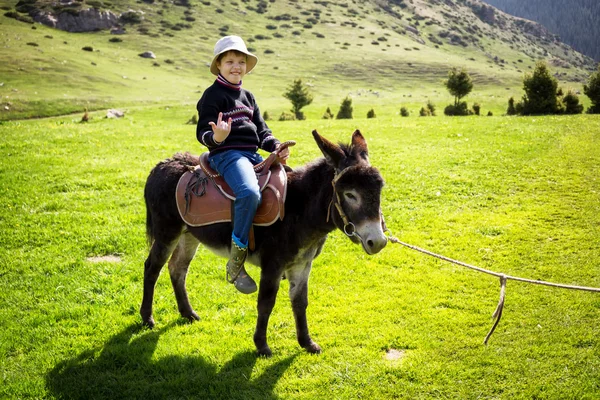 Chico monta un burro — Foto de Stock