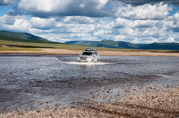 Touristes dans les voitures traversant la rivière — Photo