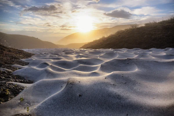 Sunrise over snowfield in highlands — Stock Photo, Image