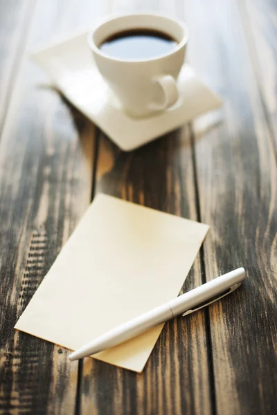 Note, paper, pen and cup of coffee on a wooden table — Stock Photo, Image