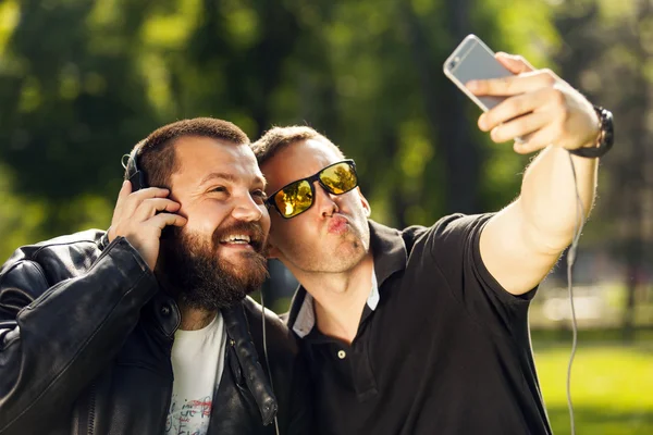 Two friends taking a selfie photo with mobile smart phone