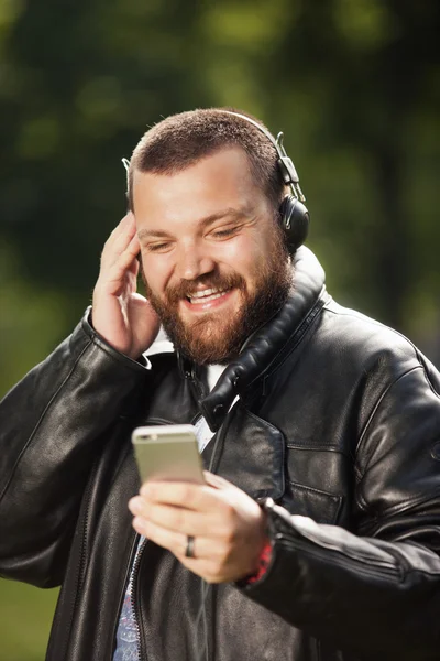 smiling man with beard holding  phone