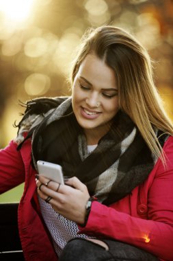 Güzel genç kadın geç yaz sonbaharda istimal hareket eden telefon