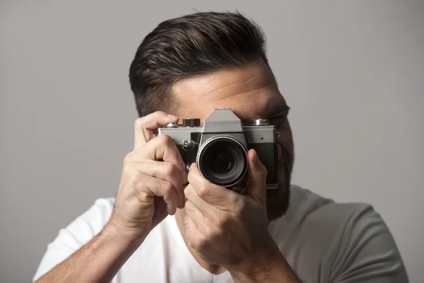 Hombre guapo sosteniendo cámara de película manual tomando fotos — Foto de Stock